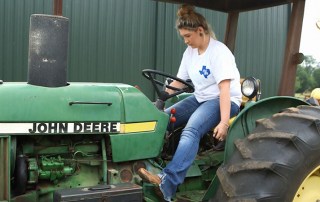 Female Member driving tractor