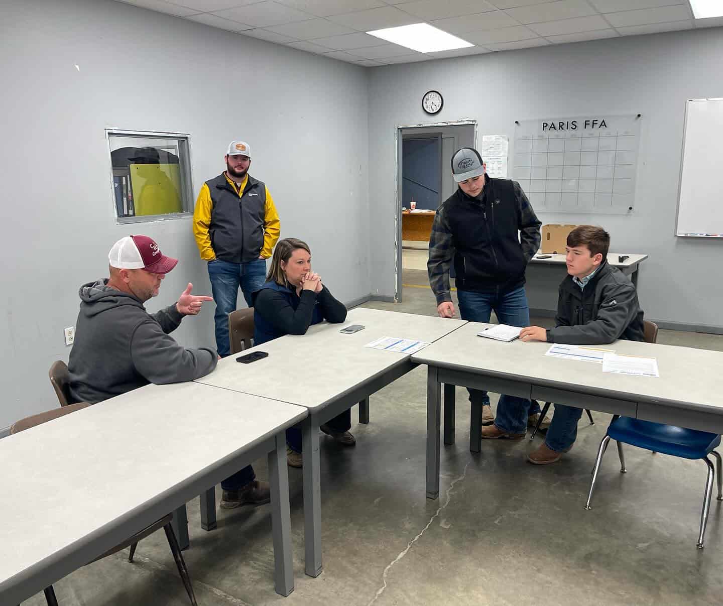 Paris FFA members Gage Benskin and Reid Ragsdale (seated on the right) collaborate with Brevant seeds representatives to sharpen their sales skills.