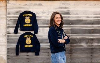 Margeaux Stewart, standing by her FFA jackets, showcasing her growth within the organization.