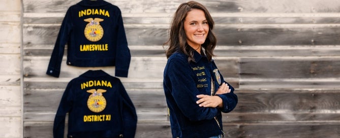Margeaux Stewart, standing by her FFA jackets, showcasing her growth within the organization.