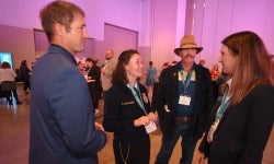 Four FFA Alumni talking at an event.