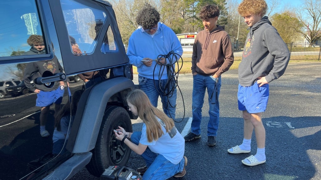 Prior to their chapter’s “Inflation Station” event, Beauregard FFA members Alleria Dupree, Brayan Mendoza, Hector Gonzalez and Miles Langley participate in a training on one of their personal vehicles. Photo courtesy of Jerad Dyess.