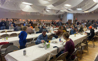 A large crowd of all ages enjoying the benefit steak dinner in Calamus, Iowa. The labor auction followed the dinner for approximately one hour