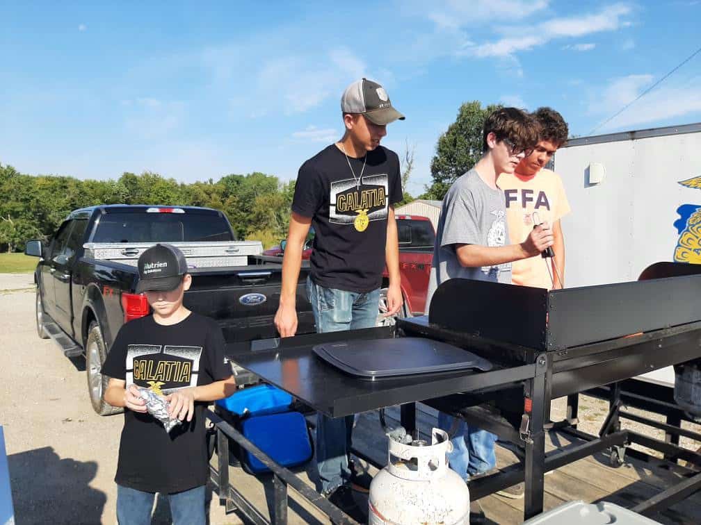 Graham (second from right) and chapter members grill hot dogs at the Section 25 Golf Scramble, helping fuel players, volunteers and his passion for service. This event helped bring funds back to his FFA section.