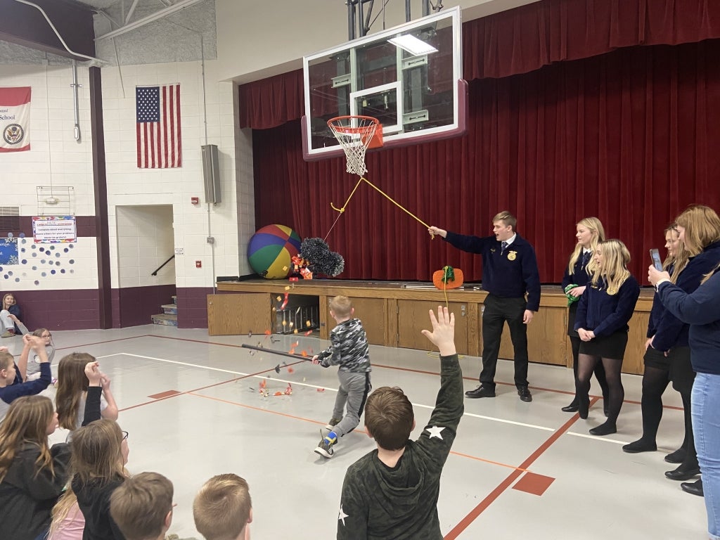 Cambridge FFA members hold piñatas for elementary students to break as part of the “Dia de la Agricultura” program. Photo courtesy of Trenton Taber.