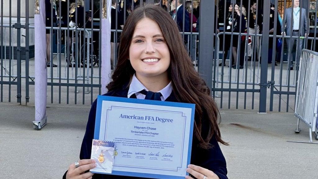 Hayven Chase smiles with her American FFA Degree and certificate in front of Lucas Oil Stadium in Indianapolis. Photo courtesy of Hayven Chase.