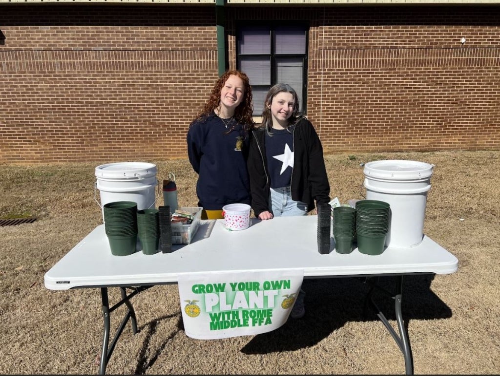 Edwards (left) and another Rome Middle FFA member (right) prepare to lead event attendees through the seed-planting station. Photo courtesy of Rome Middle FFA.