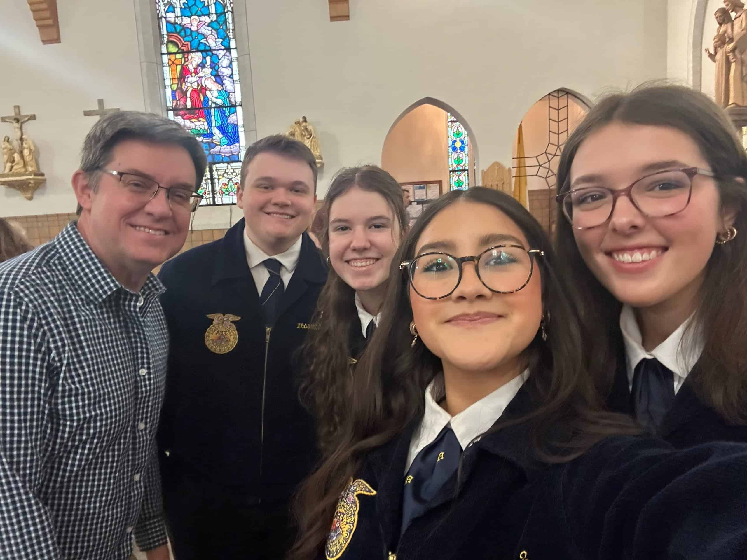The seniors and Mr. Steber pose for a selfie at a church service during National FFA Week.