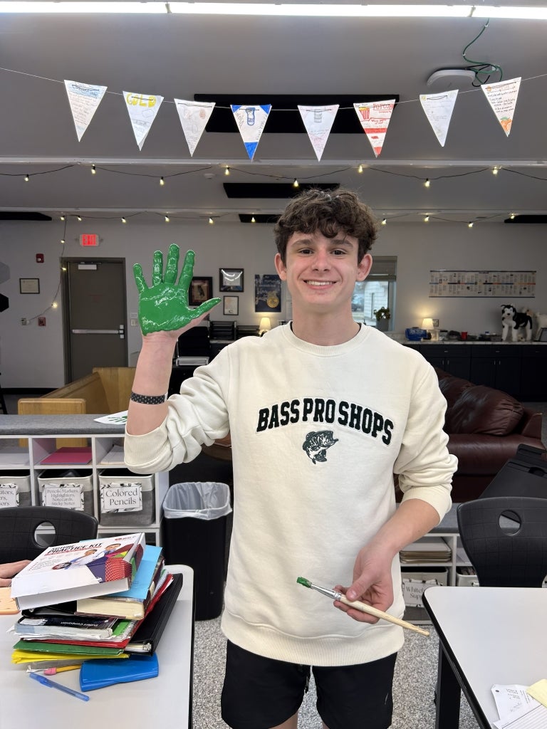 When Giltner FFA members earn their Greenhand Degree, they put a green handprint on their classroom wall. Brody Rudy proudly displays his painted hand. Photo courtesy of Kelsey Schulte.