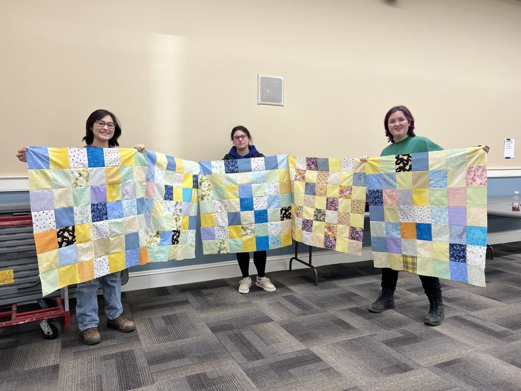 Past Norfolk FFA officers Miru Kunst (left), Gabriella Pannone (middle) and Jaxon Sennott (right) display their completed quilt tops. Photo courtesy of Miru Kunst.