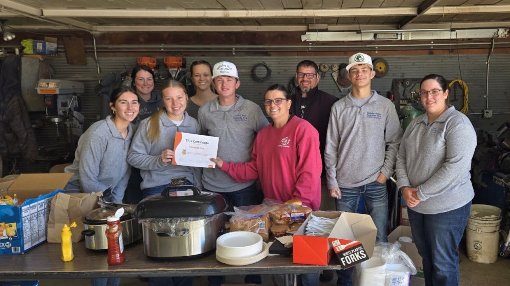 Riverside FFA members take a break from preparing meals to accept a certificate recognizing their participation in the Zoetis Industry Support Program. Photo courtesy of Lacey and Nicholas Berger.