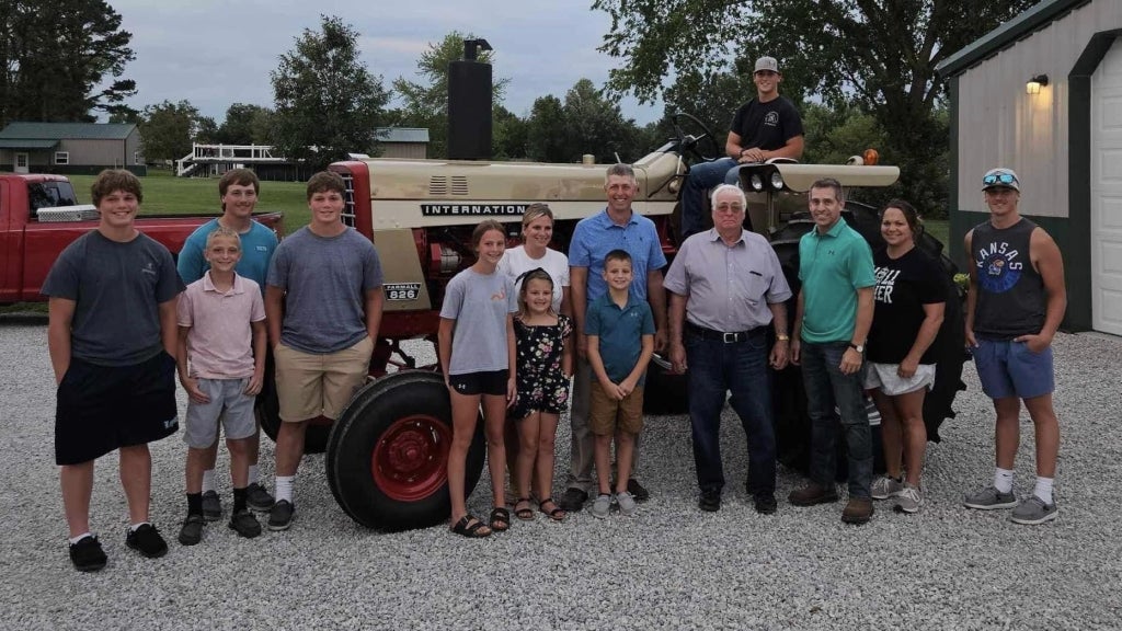 Kendall Borts (seated on the tractor) and Schoenthal family members smile with the completed tractor. Photo courtesy of Kendall Borts.