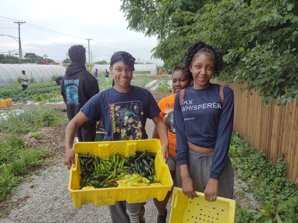 Students smile with their hand-picked peppers. Photo courtesy of Amanda Anderson.