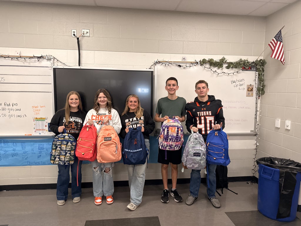 The Liberty Center FFA Service Committee presents the first backpacks of the 2025-26 school year. Pictured, from left: Mackenzie Keller, Alyvia Meyer, Maddie Sattler, Cole Bauman and Baxter Barrett. (Photo credit: Owen Gebers)