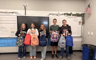 The Liberty Center FFA Service Committee presents the first backpacks of the 2025-26 school year. Pictured, from left: Mackenzie Keller, Alyvia Meyer, Maddie Sattler, Cole Bauman, and Baxter Barrett.