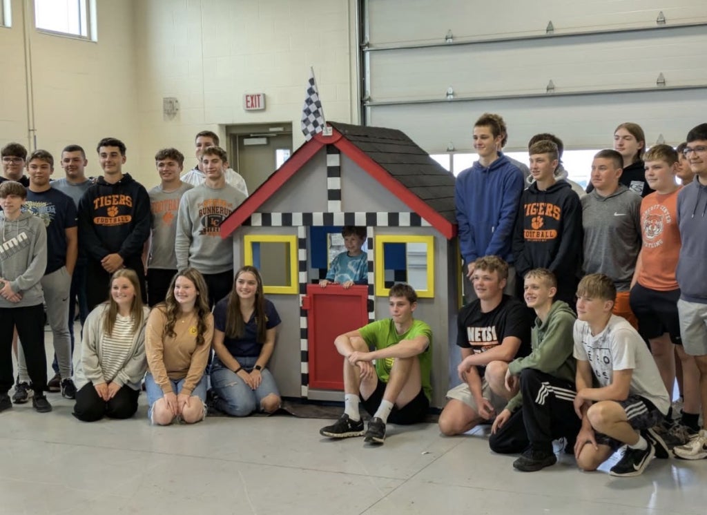 FFA members who contributed to the production of the playhouse proudly present it to its new owner.