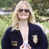 Emily Potts, wearing a dark blue corduroy FFA jacket and a white dress.