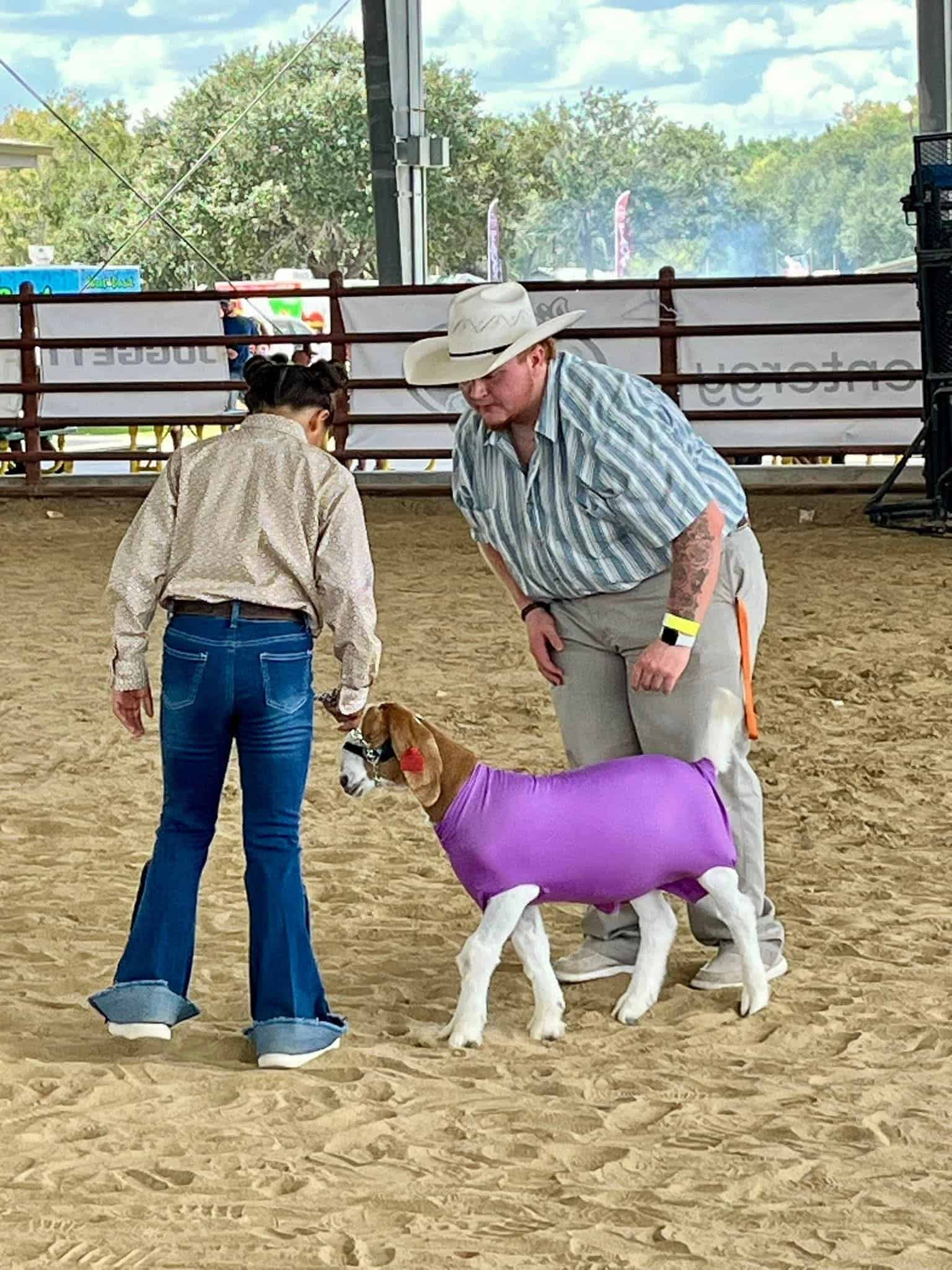 Greyson guides a young student in goat showmanship. 