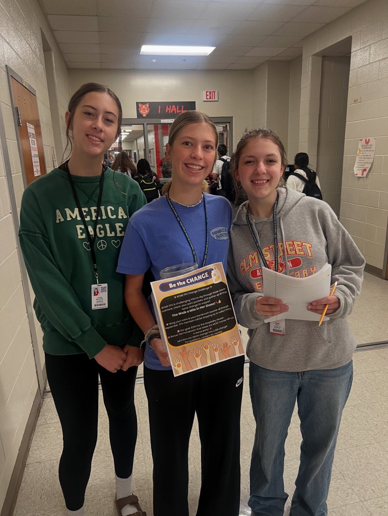 Rome Middle FFA Members Lilyana Borromoe ( Left) Kieran Newby ( Middle) Celeste Adair (Right) holding a " Be The Change" Flyer.