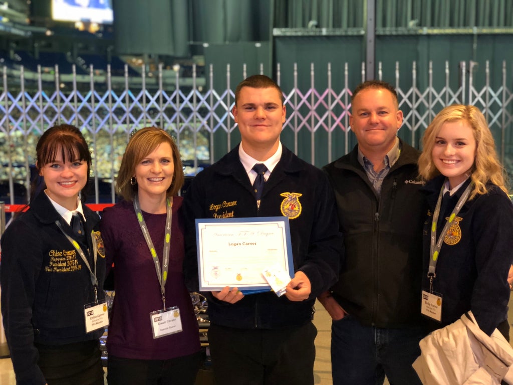 The Carver family stands with Logan after he received his American FFA Degree.