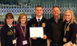 A picture of the Carver family standing with Logan after he received his American FFA Degree