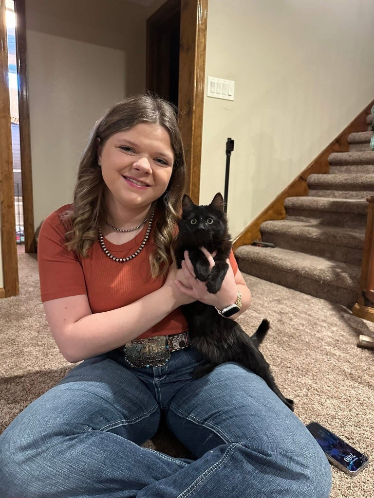 Rosner shows off Toothless, a foster cat with a rare neurological disorder causing severe balance issues and constant swaying.