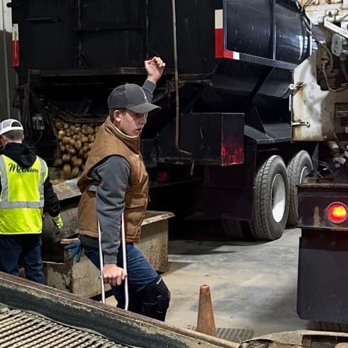 Mars Hill FFA member Collin McCrum gives back up directions to a potato truck driver.