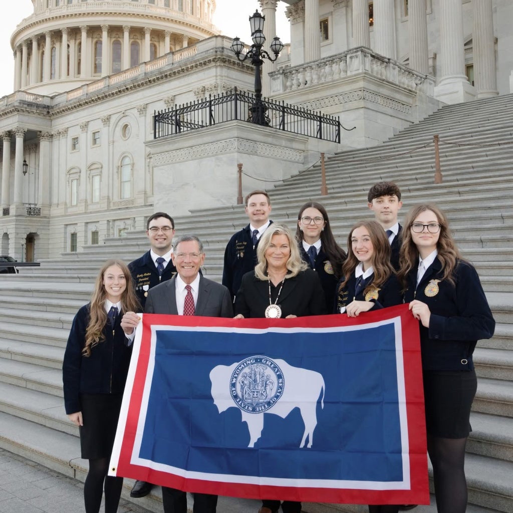 Members of the Cheyenne Frontier FFA Agricultural Issues Forum team pose with Senators Cynthia Lummis and John Barrasso in front of the United States Capitol.