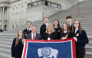Members of the Cheyenne Frontier FFA post with Senators Cynthia Lummis and John Barasso in front of the United States Capitol