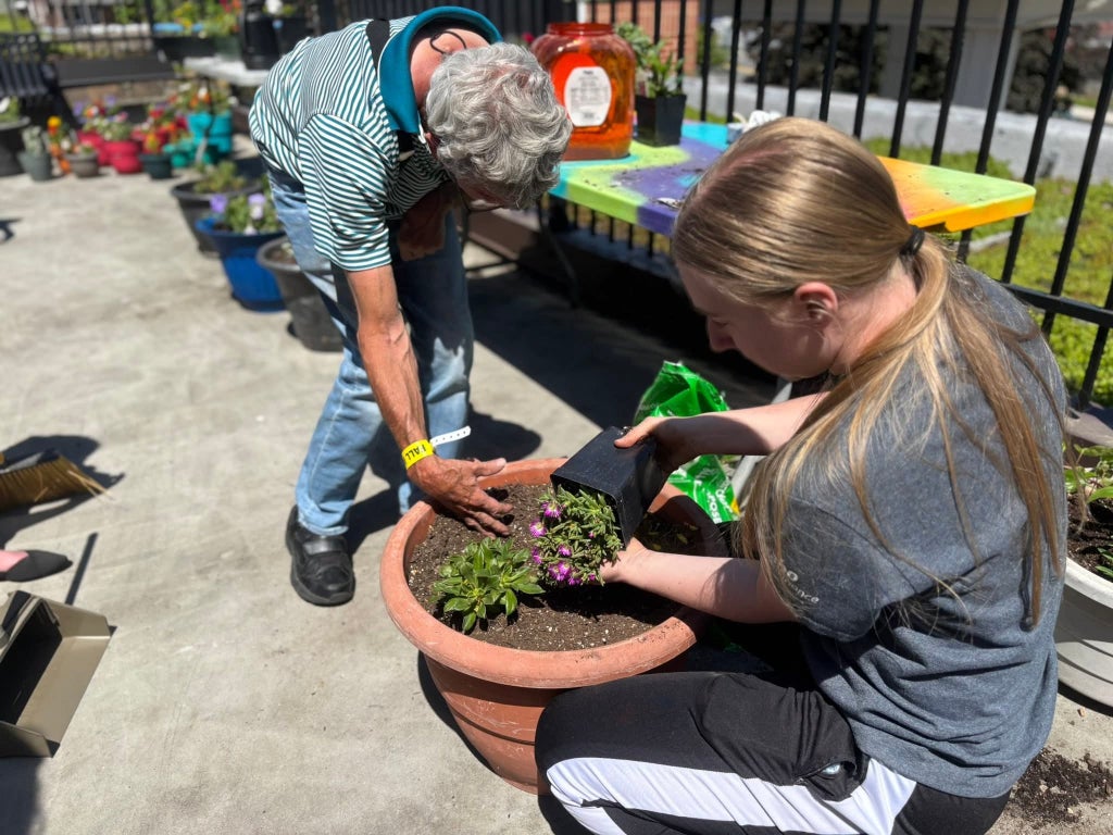 FFA member Nora Hoy aids in making mixed planters with the Cedarwood residents.