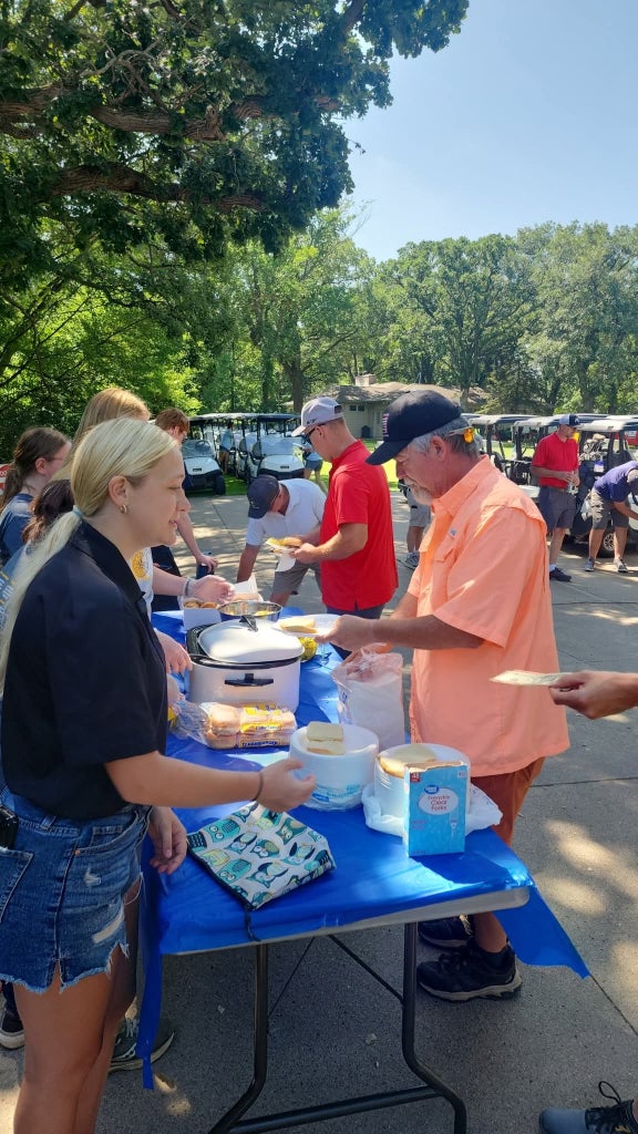 FFA members serve BBQ sandwiches at a local scholarship golf tournament.