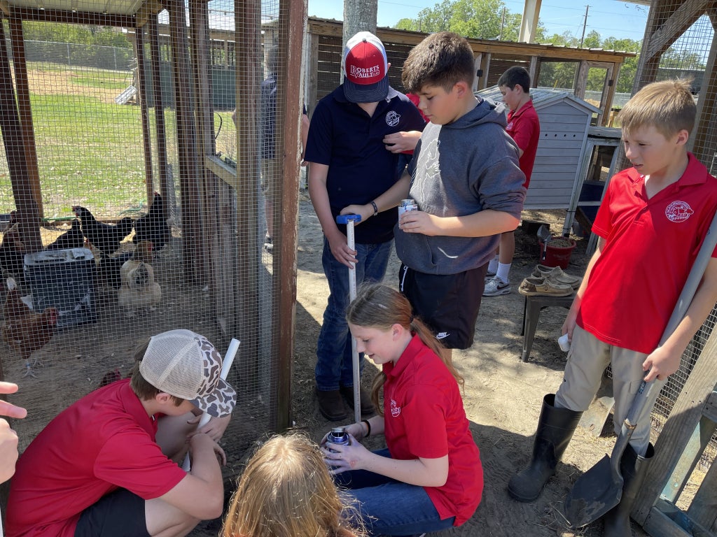 Students work together to repair one of the school’s chicken coops. Photo courtesy of Robin Carter.