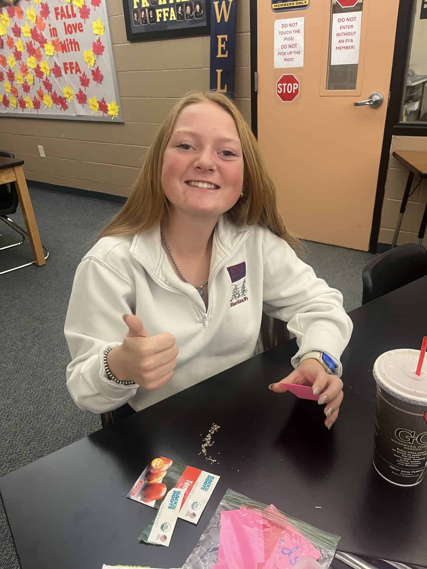 Cheyenne Frontier FFA Treasurer Katalyna Wolski carefully fills seed packets with tomato seeds.