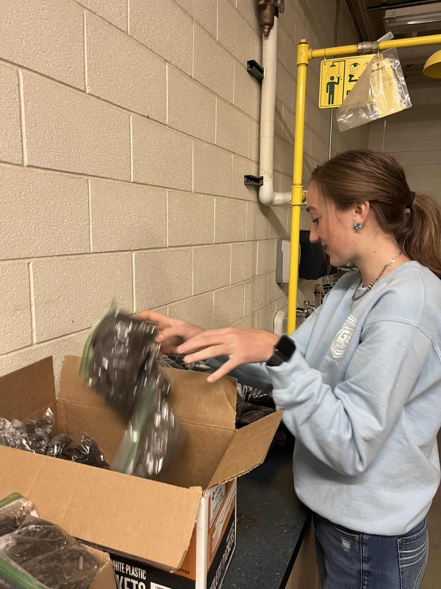 Regan Allen, Cheyenne Frontier FFA Vice President and Building Communities Committee member, packs up soil packets.