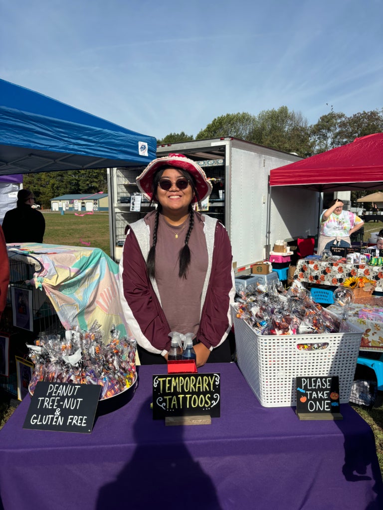 Member Audrey Serajose running a Halloween candy bag table for the community.