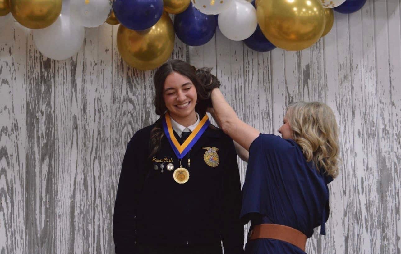 North Clay FFA Advisor, Mrs. Van Dyke, helping to fix Cash's hair before she poses for a photo with her newly-awarded community service award at the 2025 North Clay FFA Chapter banquet.