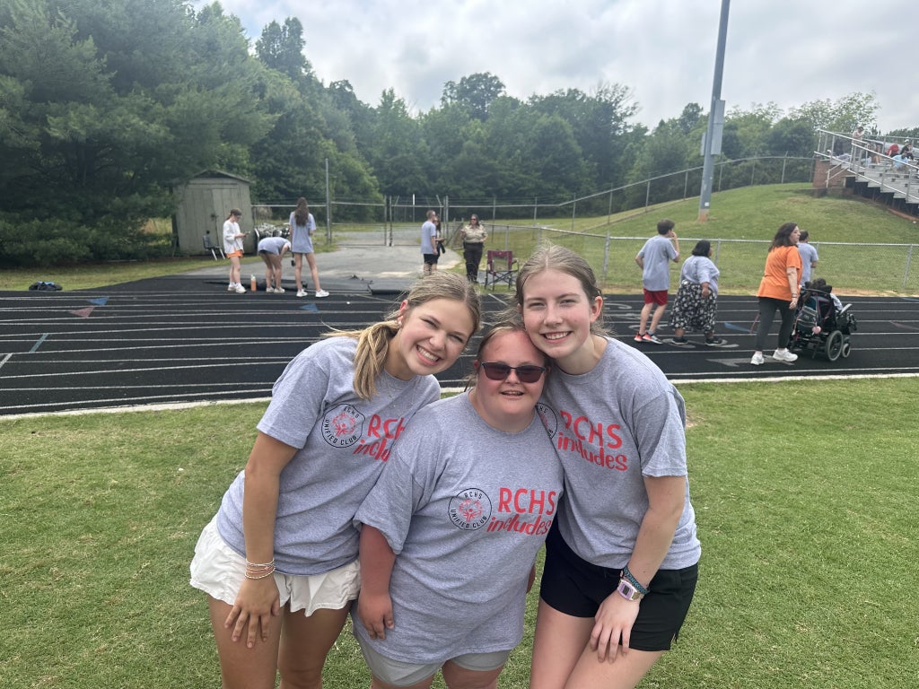Hannah Hinshaw (right), along with two of her peers, smile at the first Rockingham County High School Unified Kickball Game.