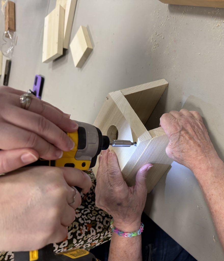 Steady hands and teamwork bring each birdhouse to life!