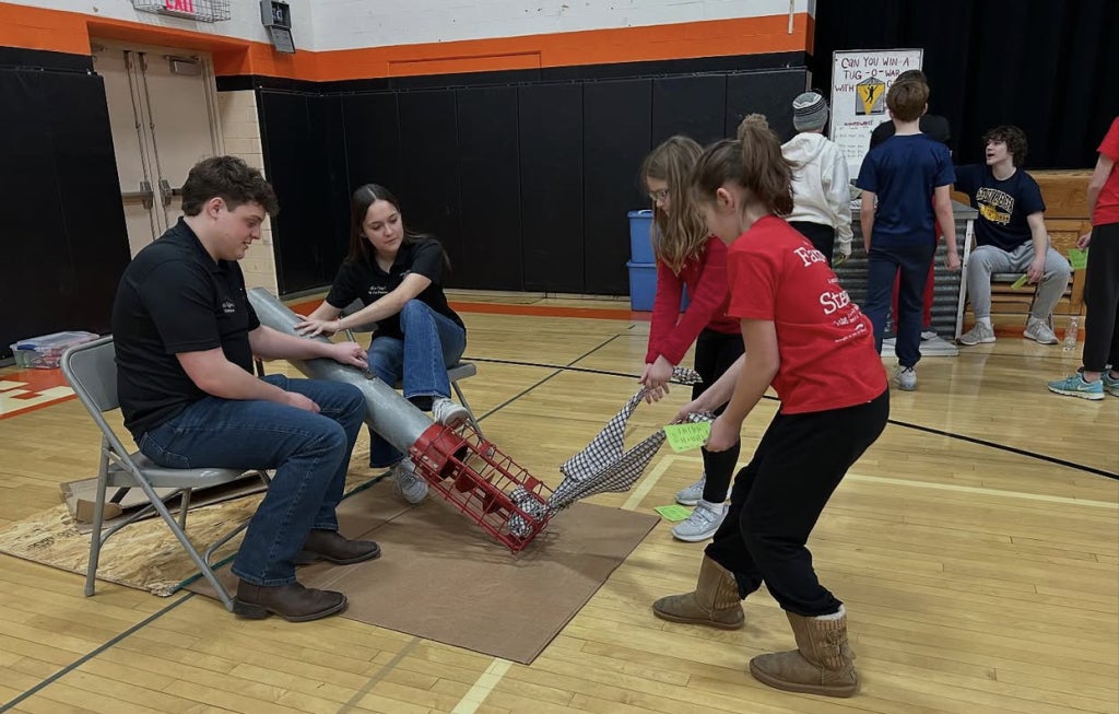 Chapter officers Charlie Hoffmann and Alex Confer teach students about auger safety