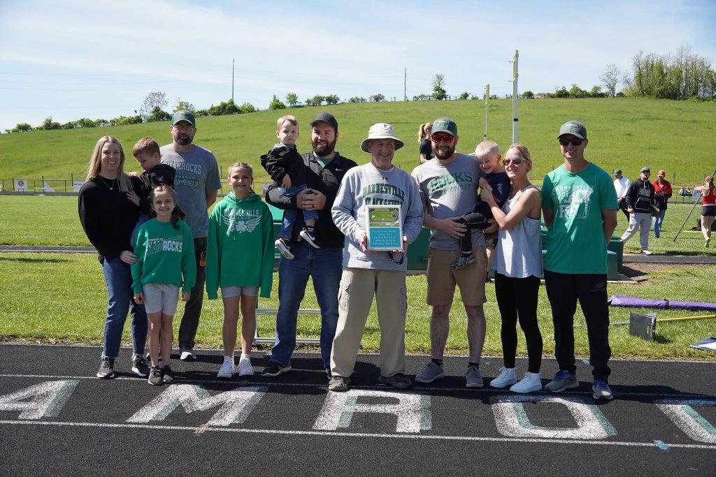 Barnesville High School honored longtime track and cross country coach Mark Brown (center) for decades of dedication.
