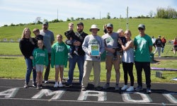 Coach Brown stands with his family and friends at Barnesville HS during a track recognition event.