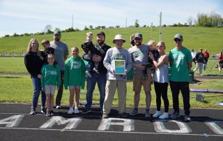 Coach Brown stands with his family and friends at Barnesville HS during a track recognition event.