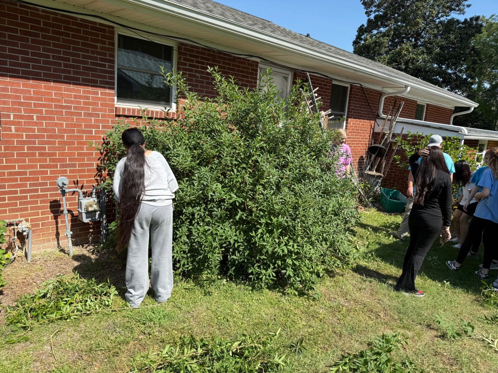 FFA members trimming a bush. 