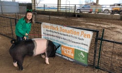 Maggie Carroll at eight years old donating her pig to Pork for Packs.