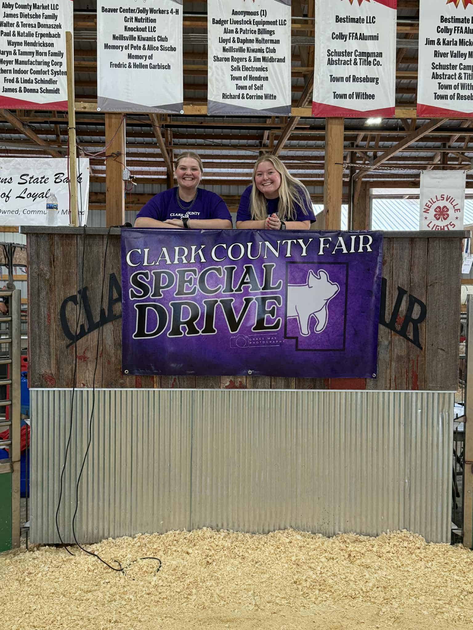 Sierra Koski (left) and Devani Hinkelmann (right) pose by the banner displaying the new inclusive program at the fair. 