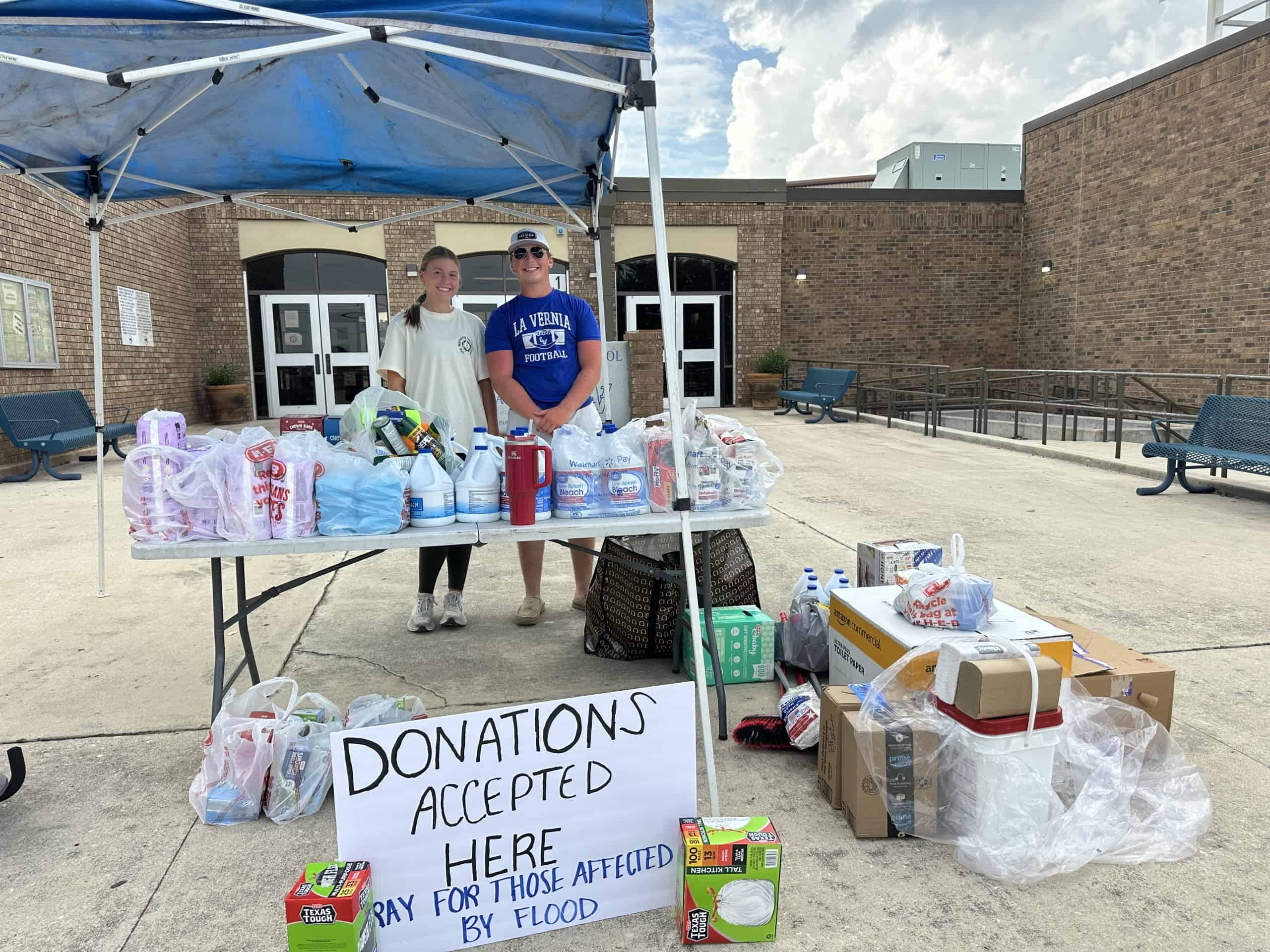 Peyton Dylla standing behind just a fraction of the donations collected for flood victims.