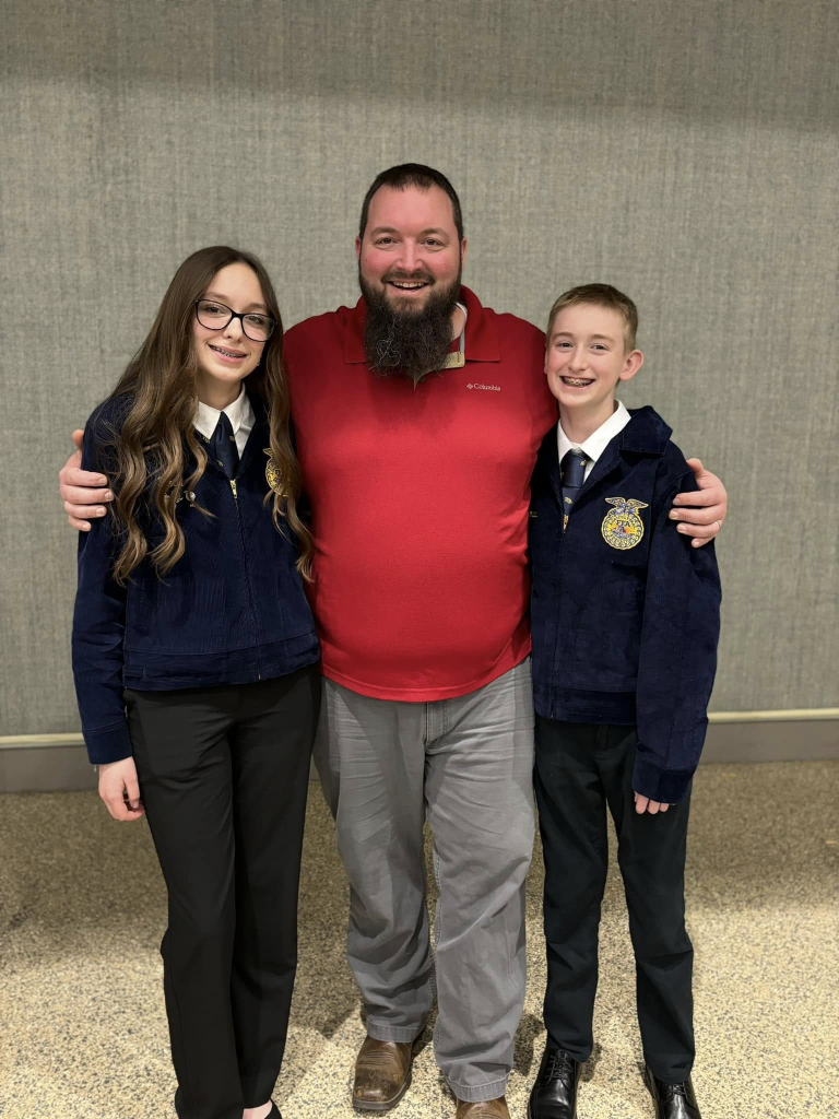 Mr. Brown (center) and two of his three children, who are FFA members.
