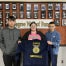 Three Barnesville FFA Freshman–Caleb Bush, Chloe Gordon, and Aiden Starr–stand in front of the Degree Hall of Fame holding their new blue FFA jacket embroidered with "Ohio" and "Barnesville."