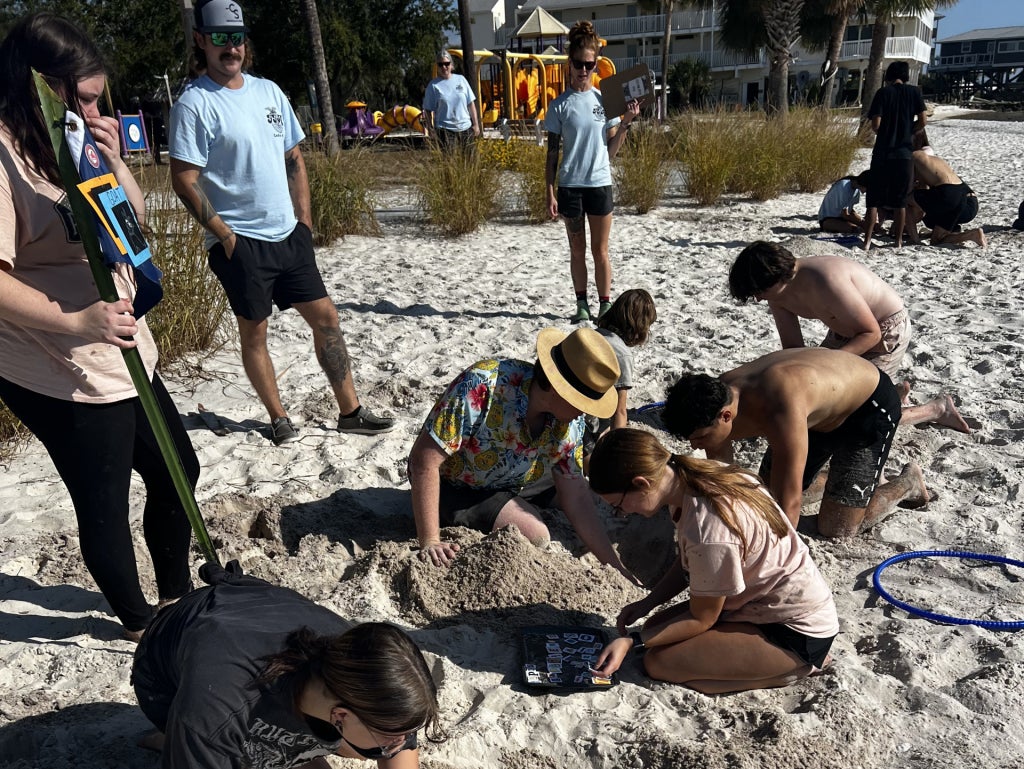 Members of the “Goat Gang” dig for letters in the word hole scramble.