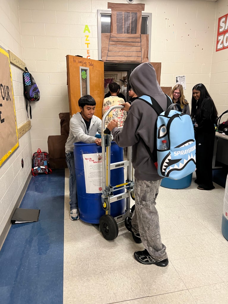 FFA Member, Addison Vicente helping load the barrel, along with other CTSO member.